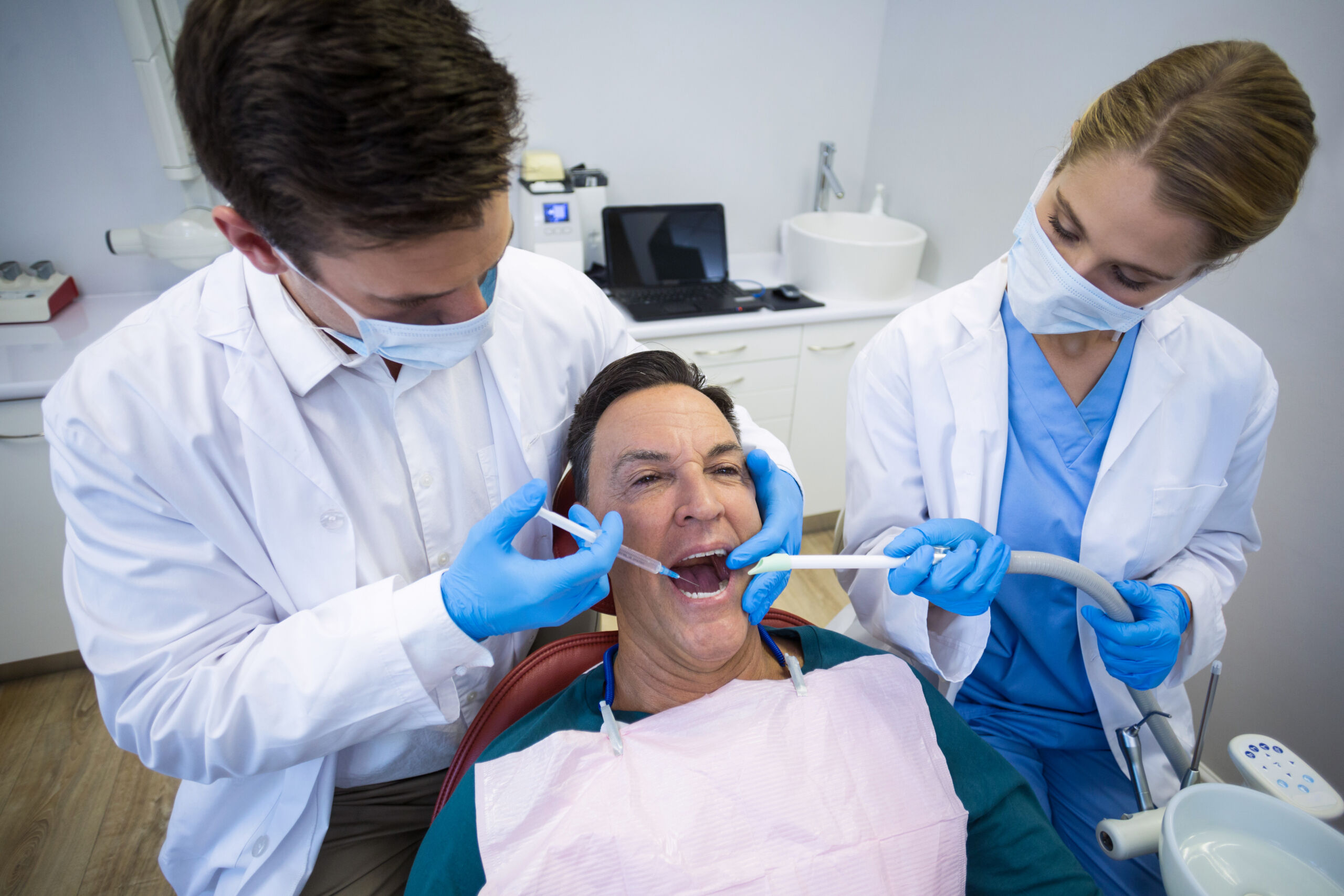 Dentists giving anesthesia to male patient Restorative Dental Treatments That Bring Back a Healthy, Confident Smile