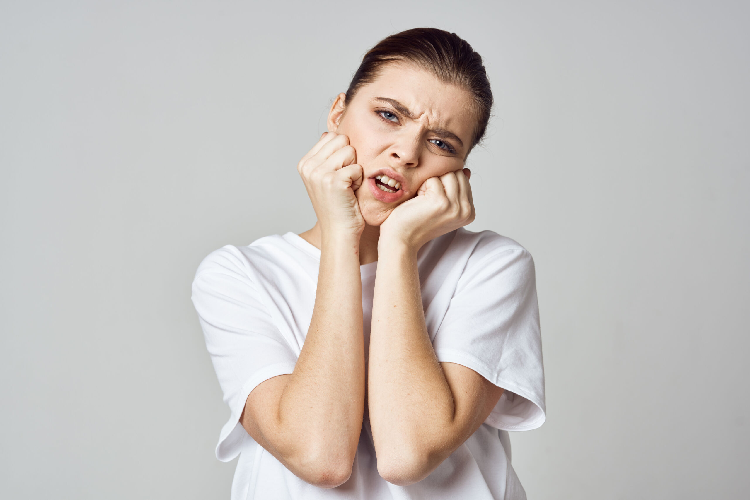 woman holding her head stress emotions discomfort pain close-up TMJ Disorders Affect Chewing, Speaking, and Sleep